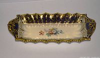 Top view showing full dish, cobalt and gold border, floral centre