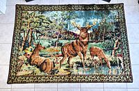 Full view of woven deer tapestry laid flat