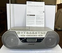 Front view of Sony CFD-S05 boombox with manual behind