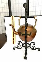 Front view of hammered copper kettle on wrought iron stand