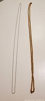 Gold-tone and silver-tone chain necklaces laid flat to show overall length and colour