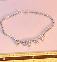 Full view of rhinestone choker necklace with rulers for scale