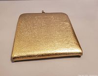 closed gold-tone compact, textured exterior