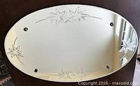 Front view of oval etched mirror showing floral designs