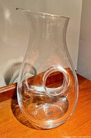 Donut-style glass decanter front view highlighting central opening and spout