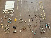 All jewelry pieces laid out showing necklaces, bracelet, earrings and rings