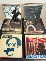Front view of four stacks showing Iggy Pop, Jimmy Reed at Carnegie Hall, Elvis, An Evening With Groucho and The Best of Basie covers