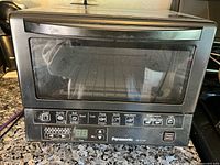 Front view of Panasonic NB-G110P toaster oven showing overall condition and control panel