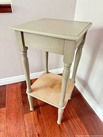Full view of end table showing painted finish and lower shelf