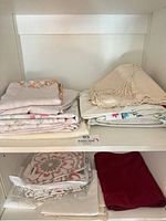 Folded tablecloths on shelves showing assorted colours and patterns