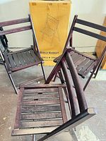 Three folding chairs displayed next to original World Market box