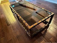 Full view of coffee table showing glass surface and wooden bamboo-style frame