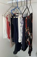 Group shot of all eight pairs of pants hanging on rod