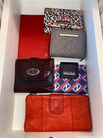 Six assorted women’s wallets arranged in drawer