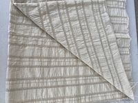 Folded cream cotton fabric showing overall yardage and reverse side