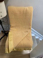 Blanket draped over chair showing overall appearance and satin edge