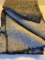 Folded wool blanket showing both charcoal and grey sides