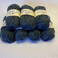 Seven balls of Debbie Bliss Cotton Denim yarn stacked