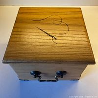 Top view of oak sewing box showing burned needle and thread design