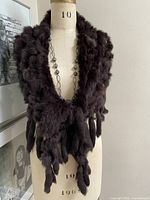 Full view of shawl draped on mannequin showing triangular shape and fringe