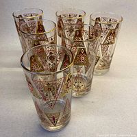 Front view of six tumblers showing pattern and gold rims
