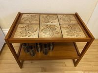 Front view showing teak frame, tile top, lower shelf