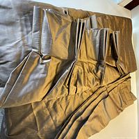 Folded pair of silk drapery panels showing pleated tops