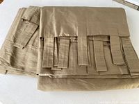 Folded silk drapery panels showing loop tabs