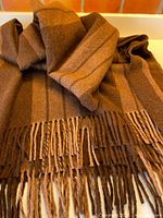 Full view of striped brown alpaca blanket with fringe