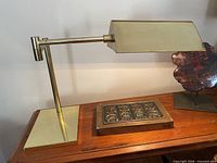 Full view of brass desk lamp on wooden surface