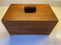 Front view showing teak box with lid and handle