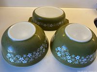 Three inverted Pyrex Spring Blossom pieces showing exterior pattern and maker marks