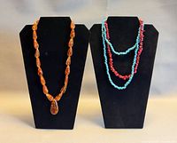 Overall view of three necklaces on two stands