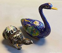 Elephant and swan figurines side by side