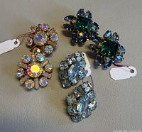 Overview of three pairs of rhinestone earrings on surface