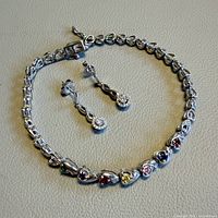 Bracelet and earrings laid flat showing design and stones