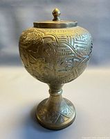 Full view of brass lidded urn on pedestal