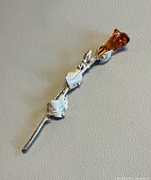 Full view of silver-tone stem brooch with amber bloom