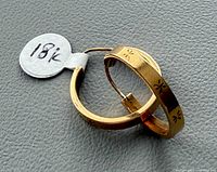 Front view of both gold hoop earrings with 18K tag visible