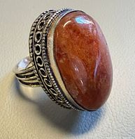 Front view of sterling silver ring with large oval sunstone cabochon