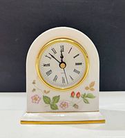 Front view of Wedgwood Wild Strawberry bone china mantel clock showing pattern, dial and gold bezel