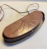 Front angled view of brown layered metal sconce light showing decorative fan relief