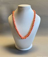 Full view of coral necklace on display bust