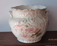 Front view of floral embossed jardiniere planter showing overall design and scalloped rim