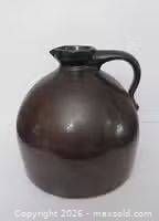 Front view of brown stoneware jug showing overall shape and handle