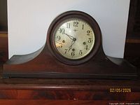 Front view of New Haven tambour mantel clock showing dial, bezel and mahogany case