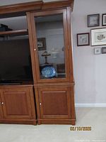Front view of wood display cabinet adjacent to TV unit
