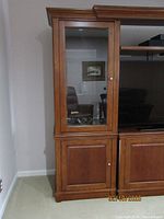 Full view of the display cabinet showing glass door and wood finish