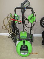 Full view of pressure washer on wheeled cart with hose reel, power cord, high-pressure hose and nozzle storage