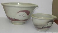 Both ceramic bowls side by side showing size difference and exterior motif